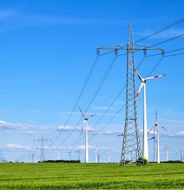 power-technology Power lines in a green field with blue sky and clouds