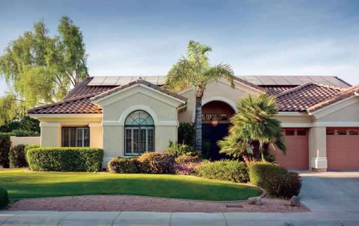 Western styled home with green landscaping and solar panels