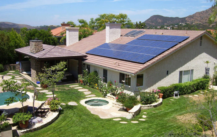 Sky view image of a residential back yard with a pool and solar panels