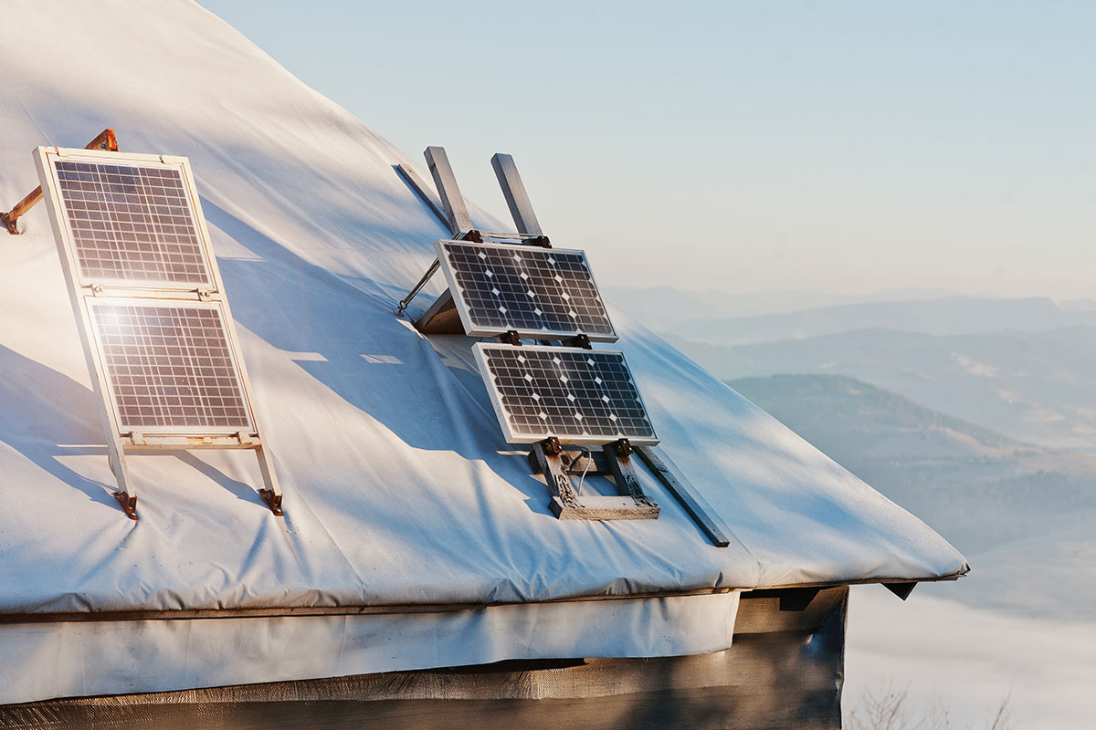 Solar panels on a log cabin in the snow