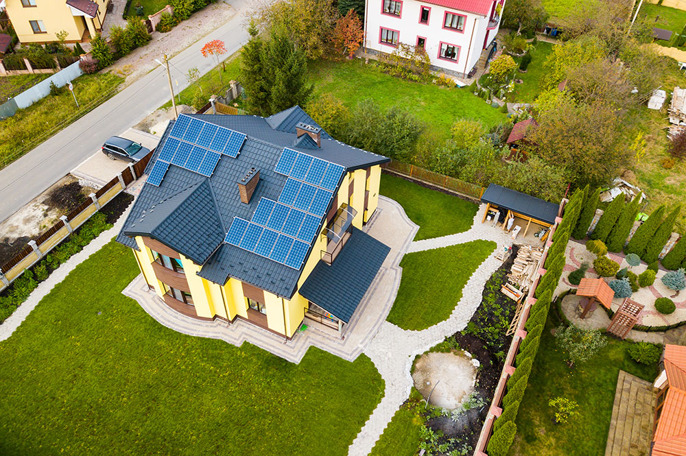 Ariel photo of a suburban, cottage style home with new solar panels