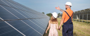 A child and a solar expert looking at solar panels