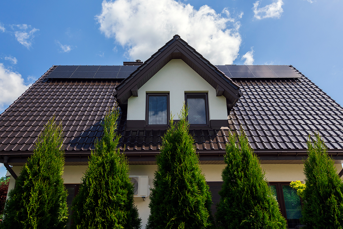 Solar panels on the house roof in sunny day. Renewable clean green energy generation.