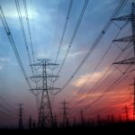 Power lines under an overcast red and blue sky